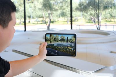 Duy Luân đang xem mô hình trụ sở Apple trên iPad